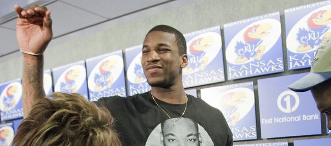 Kansas junior basketball player Thomas Robinson waves to the crowd after he declared for the NBA Draft on Monday during a press conference with KU coach Bill Self and Robinson's sister Jayla, pictured at right.