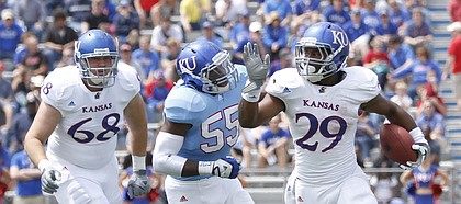 Kansas linebacker Michael Reynolds (55) chases after running back James Sims (29) during the second half of the Spring Game on Saturday, April 28, 2012 at Kivisto Field. At left is white team offensive lineman Luke Luhrsen.
