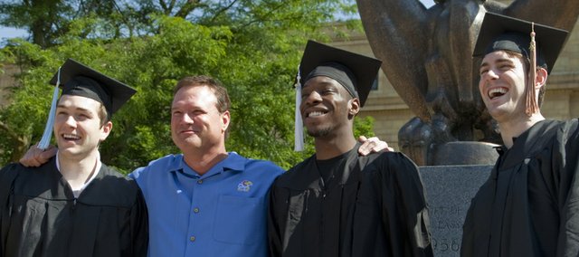 From left, KU basketball senior Jordan Juenemann, coach Bill Self, and players Tyshawn Taylor and Conner Teahan gather for a photograph before Sunday's KU commencement at Memorial Stadium.