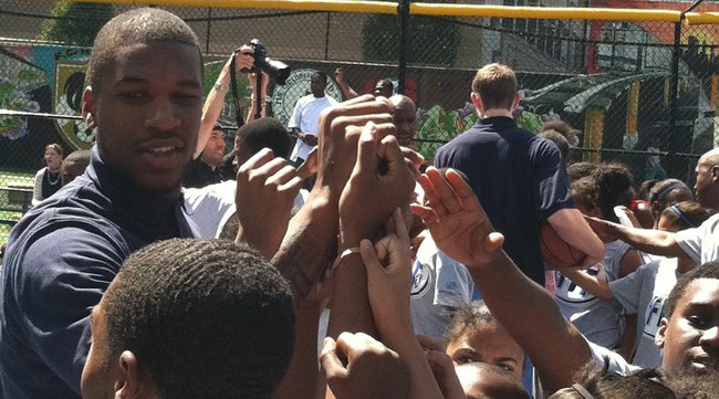 Former Kansas forward Thomas Robinson puts his hand in a break with children during the NBA Fit event near Harlem, New York, on Wednesday, June 27, 2012.