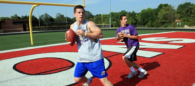 Lawrence High quarterback Brad Strauss, right, works out with former Kansas University quarterback Jordan Webb on Friday, June 29, 2012, at LHS. Strauss has tried to prepare for his senior season in the fall by spending much of the spring and summer training with Webb.