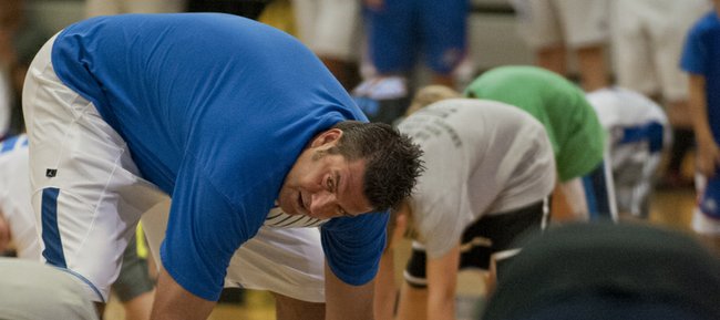 Former KU player Mark Randall, left, leads a warm-up exercise during the Cole Aldrich basketball camp Monday, July 9, 2012, at Olathe Northwest High School.