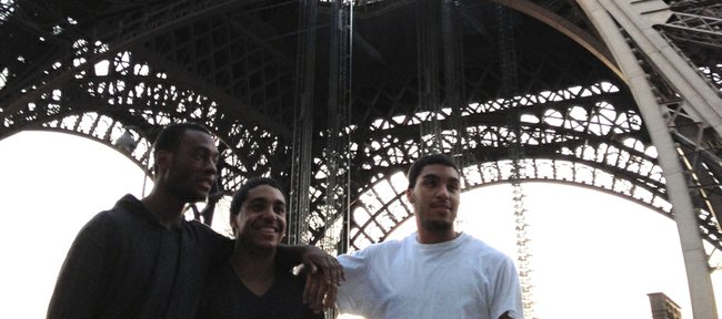 Kansas guard Naadir Tharpe, left, and guard Niko Roberts, right, stop for a photo in front of the Eiffel Tower in Paris with Niko's younger brother Justin on Thursday, Aug. 9, 2012.