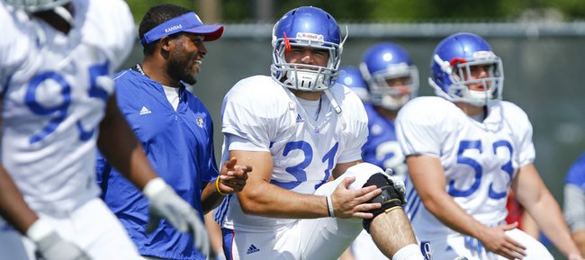 Kansas University linebacker Ben Heeney laughs with graduate assistant Maurice Crum during practice, Tuesday, August 14, 2012, near Memorial Stadium. Heeney, a sophomore, wants to start for the Jayhawks this year and might get the chance if he continues to impress coaches as he has during fall camp.