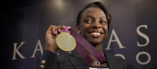 Kansas University runner and Olympic athletic Diamond Dixon shows off her gold medal during a press conference at KU's Anderson Family Football complex on Wednesday.