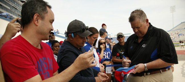 Kansas head coach Charlie Weis signs an autograph for Ivan Valdivia, Shawnee following the Spring Game on Saturday, April 28, 2012 at Kivisto Field. At left is Eric Smith, also of Shawnee.