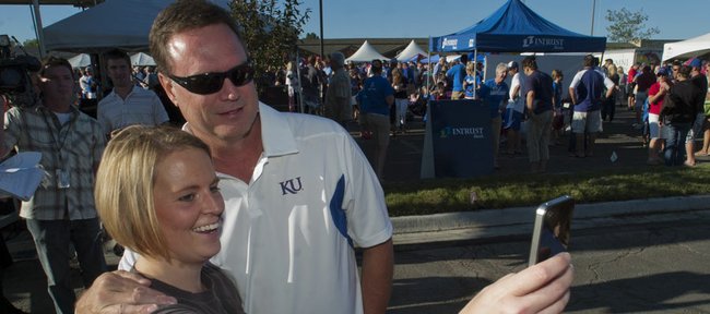Kansas fan Jennifer Coughenour snaps a quick photo with KU men's basketball coach Bill Self on Friday before the KickOff at Coringth Square in Prairie Village for the KU football season.