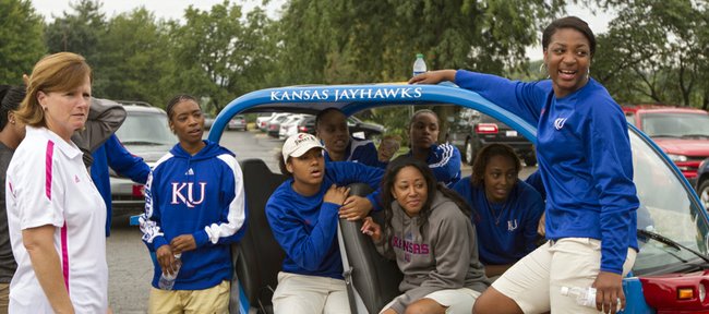 Kansas women's basketball coach Bonnie Henrickson, left, hangs out with members of her team around a Jayhawk-themed golf cart before the start of the eighth annual Bonnie Henrickson Golf Tournament on Saturday, August 25, 2012, at Alavamar.