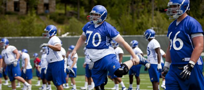 Kansas offensive lineman Gavin Howard stretches out as the team warms up during practice on Thursday, Aug. 2, 2012.