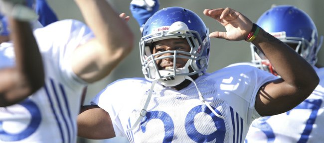 Kansas running back James Sims smiles as he stretches with his teammates during practice on Tuesday, Sept. 18, 2012. Sims is expected to return against Northern Illinois after serving a three-game suspension.