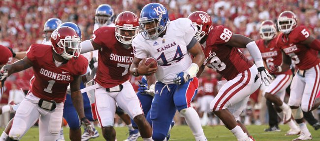 Kansas quarterback Michael Cummings is swarmed by Oklahoma defenders Tony Jefferson (1) Corey Nelson (7) and Chuka Ndulue (98) during the first quarter on Saturday, Oct. 20, 2012 at Memorial Stadium in Norman.