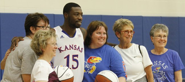 Senior Elijah Johnson, (15) has a photograph taken with women attending Ladies Night Out with Bill Self in Allen Fieldhouse Wednesday evening, Oct. 24, 2012. Women got a chance to run drills, get their photographs taken with and receive one-on-one instruction in basketball from members of the Kansas University men's basketball team and staff.
