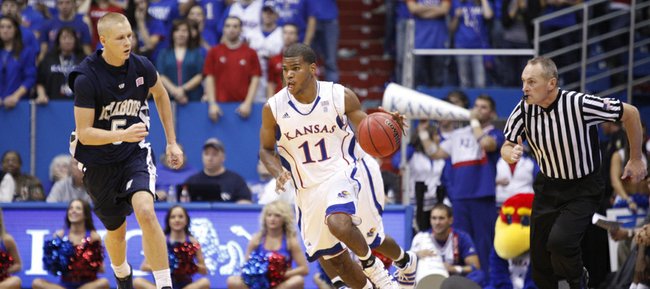 Kansas guard Royce Woolridge pushes the ball up court past Washburn's Jeff Reid in the second half of the exhibition game, Tuesday, Nov. 2, 2010 at Allen Fieldhouse.