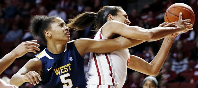 West Virginia's Averee Fields (5) reaches around Oklahoma's Nicole Griffin (4) for a rebound during the second half of their NCAA college basketball game, Wednesday, Jan. 2, 2013, in Norman, Okla. Oklahoma won 71-68.