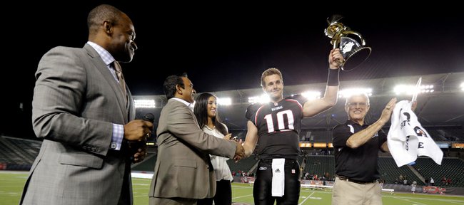 National team quarterback Dayne Crist (10) of Kansas holds up the trophy as head coach Dick Vermeil, right, and NFLPA Executive Director DeMaurice Smith celebrate after the NFLPA Collegiate Bowl on Saturday, Jan. 19, 2013 in Carson, Calif. (Ric Tapia/AP Images for NFLPA)