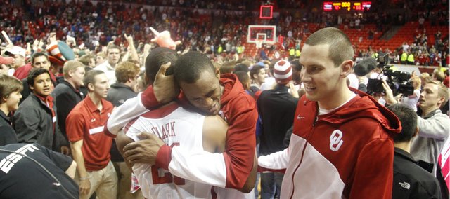 Oklahoma players Amath M'Baye hugs teammate Cameron Clark as the Sooners celebrate their 72-66 win over Kansas on Saturday, Feb. 9, 2013 at Noble Center in Norman, Oklahoma.