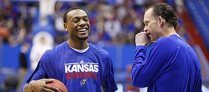 Kansas guard Naadir Tharpe laughs with assistant Joe Dooley prior to tipoff against West Virginia on Saturday, March 2, 2013 at Allen Fieldhouse.