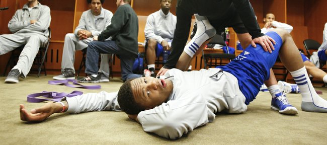 Kansas guard Ben McLemore and Andrea Hudy, assistant athletic director for sport performance watch the Colorado State and Louisville game as McLemore is stretched in the locker room before the team's practice, Saturday, March 23, 2013 at the Sprint Center in Kansas City, Mo.