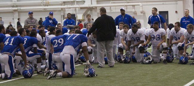 Kansas football coach Charlie Weis addresses his players during spring practice on March 9, 2013, at Anschutz Sports Pavilion.
