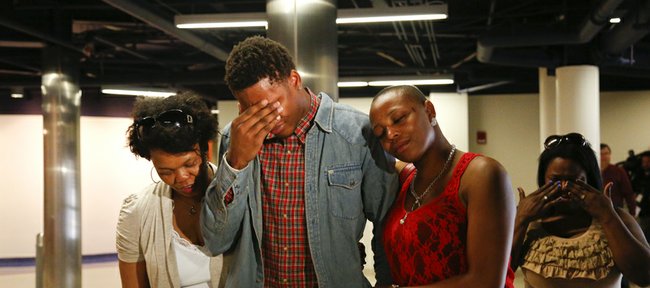 Kansas guard Ben McLemore wipes away tears as he leaves a news conference with family members after declaring his intention to enter the 2013 NBA Draft. At left is his mother, Sonja Reid Nick Krug/Journal-World Photo