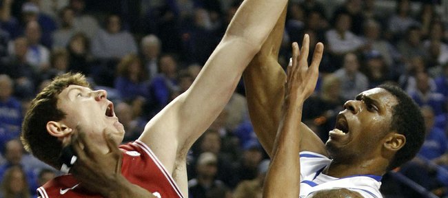 Kentucky's Terrence Jones, right, puts up a shot under pressure from Arkansas' Hunter Mickelson (21) and Marvell Waithe during the first half of an NCAA college basketball game in Lexington, Ky., Tuesday, Jan. 17, 2012.