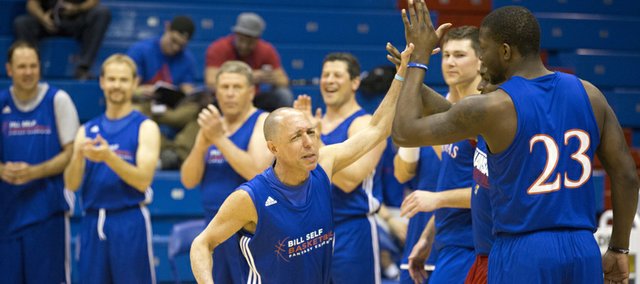 Richard Rosenzweig slaps hands with former Kansas player Mario Little as he is introduced before a game at the Bill Self Fantasy Camp on Thursday, May 2, 2013, at Allen Fieldhouse. 