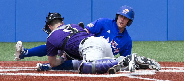 Kansas' Michael Suiter looks to the umpire for a call after sliding into home under the tag by Kansas State catcher Blair DeBord during the final game of Kansas' three game home series against Kansas State Sunday at Hoglund Ballpark. The Wildcats swept the series.