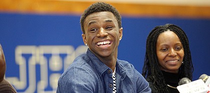 Huntington Prep basketball player Andrew Wiggins smiles along side his mother Marita Payne-Wiggins, right, as he announces his commitment to Kansas University during a ceremony on Tuesday, May 14, 2013, at St. Joseph High School in Huntington W.Va. The Canadian star, a top prospect, averaged 23.4 points and 11.2 rebounds per game this season for West Virginia's Huntington Prep.