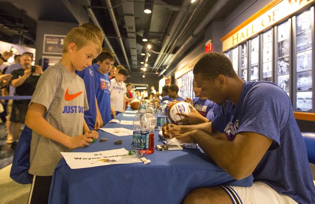 Eight-year-old Jackson Noland waits as Kansas freshman Wayne Selden signs his T-shirt during an autograph session for attendees of Bill Self's basketball camp Sunday at Allen Fieldhouse. 