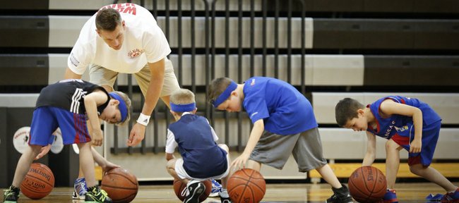 Sacramento Kings player and former Kansas center Cole Aldrich watches as young basketball players have a bit of trouble completing a ball-handling drill on Monday, June 24, 2013, during Aldrich's basketball camp at Olathe Northwest High School. 