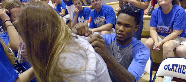 Former Kansas basketball player Ben McLemore signs autographs for fans at the Mario Chalmers All Pro Celebrity basketball game Thursday at Olathe East.