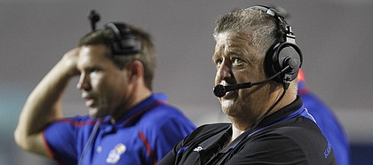 Kansas head coach Charlie Weis looks up at the scoreboard late in the fourth quarter against Rice, Saturday, Sept. 14, 2013 at Rice Stadium in Houston, Texas. At left is linebackers coach Clint Bowen.