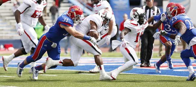 Kansas linebacker Ben Heeney (31) can't hang on to Texas Tech running back DeAndre Washington as he heads in for a touchdown during the third quarter on Saturday, Oct. 5, 2013 at Memorial Stadium.