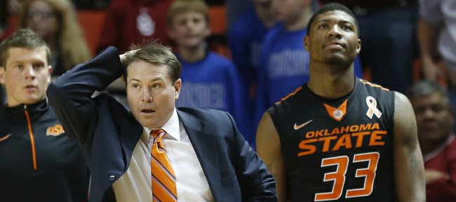 Oklahoma State head coach Travis Ford reacts to an official's call in the second half of an NCAA college basketball game against Oklahoma in Norman, Okla., Saturday, Jan. 12, 2013. Oklahoma State guard Marcus Smart (33) is at right.