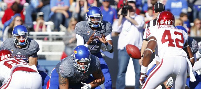 Kansas quarterback Montell Cozart takes a snap against Oklahoma during the second quarter on Saturday, Oct. 19, 2013 at Memorial Stadium.