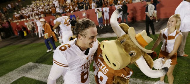 Texas quarterback Case McCoy celebrates with the team mascot after UT’s 31-30 victory over Iowa State on Oct. 3 in Ames, Iowa. The Longhorns are undefeated since McCoy took over for the injured David Ash.