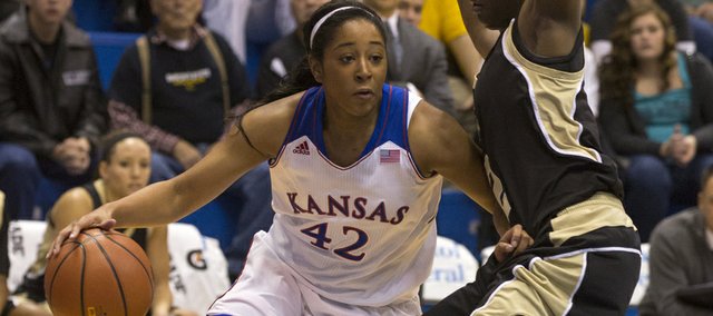 Kansas guard Natalie Knight (42) uses her off hand to create space as she drives past Emporia State's Kelly Moten (2) during their exhibition game, Sunday afternoon at Allen Fieldhouse. The Jayhawks downed the Hornets 61-53 in their final exhibition game of the season. Kansas opens its season next Sunday, Nov. 10, at home against Oral Roberts. 