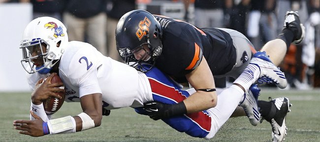 Kansas quarterback Montell Cozart is tackled by Oklahoma State linebacker Caleb Lavey during the third quarter on Saturday, Nov. 9, 2013 at Boone Pickens Stadium in Stillwater, Oklahoma.