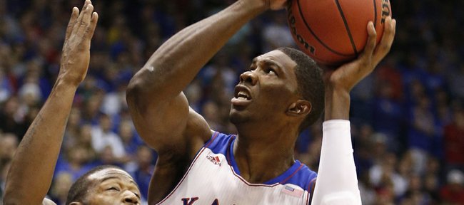 Kansas center Joel Embiid takes off to the bucket against Iona forward David Laury during the first half on Tuesday, Nov. 19, 2013 at Allen Fieldhouse.