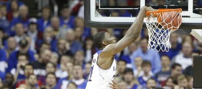 Kansas center Joel Embiid delivers a dunk over New Mexico defender Arthur Edwards during the second half on Saturday, Dec. 14, 2013 at Sprint Center in Kansas City, Mo.