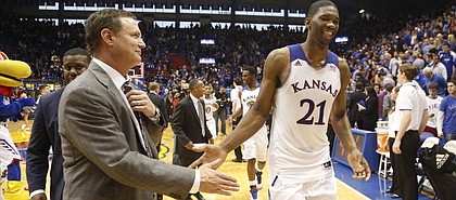 Kansas head coach Bill Self slaps hands with center Joel Embiid as he leaves the court following the Jayhawks' 86-64 win over Georgetown on Saturday, Dec. 21, 2013 at Allen Fieldhouse.