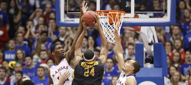 Kansas defenders Joel Embiid, left, and Perry Ellis defend against a shot from Toledo forward J.D. Weatherspoon during the first half on Monday, Dec. 30, 2013 at Allen Fieldhouse.