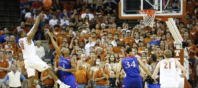 Texas forward Jonathan Holmes turns for a shot over Kansas guard Andrew White during the first half on Saturday, Feb. 1, 2014 at Erwin Center in Austin, Texas.