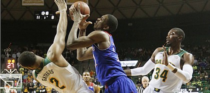 Kansas center Joel Embiid, right, draws a foul charge as he drives into Baylor player Rico Gathers during the first half on Tuesday, Feb. 4, 2014 at Ferrell Center in Waco, Texas.