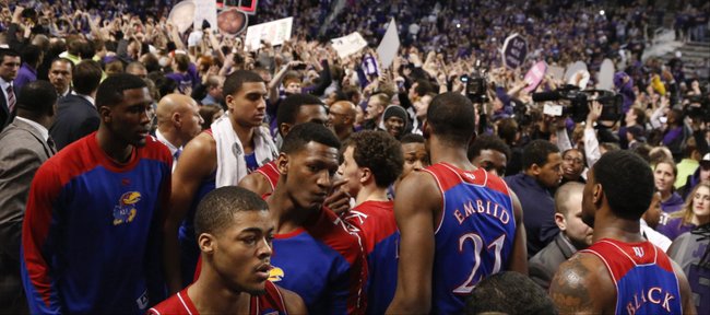 Kansas guard Frank Mason, front, and his teammates look for an exit from the court as the Kansas State student section celebrate following the Jayhawks' 85-82 overtime loss to Kansas State on Monday, Feb. 10, 2014 at Bramlage Coliseum.