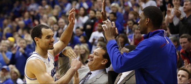 Kansas forward Perry Ellis gets a round of high fives from his teammates and coaches as he leaves the game after a 32-point effort against TCU on Saturday, Feb. 15, 2014 at Allen Fieldhouse.