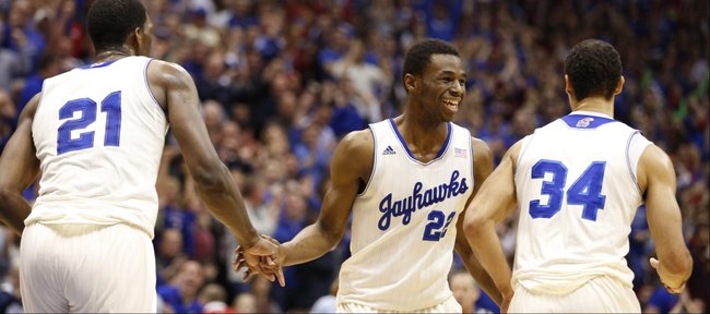 Kansas guard Andrew Wiggins slaps hands with teammate Joel Embiid after Embiid's dunk against Texas during the first half on Saturday, Feb. 22, 2014 at Allen Fieldhouse. At right is forward Perry Ellis.