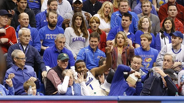 Fans react as Kansas guard Wayne Selden crashes into the seats after saving a ball that was tossed to teammate Joel Embiid for a bucket during the second half on Monday, Jan. 20, 2014, at Allen Fieldhouse.