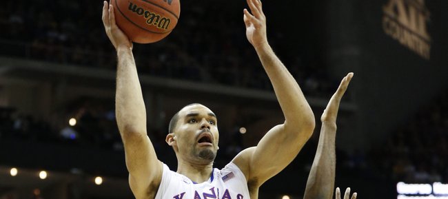 Kansas forward Perry Ellis floats in for a bucket past Iowa State forward Melvin Ejim during the first half on Friday, March 14, 2014 at Sprint Center in Kansas City, Missouri.