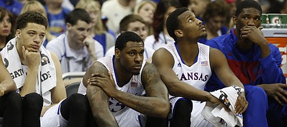 Kansas players Brannen Greene, left, Tarik Black, Wayne Selden, and Joel Embiid, sit quietly on the Jayhawks' bench as Iowa State begins to pull away in the second half on Friday, March 14, 2014 at Sprint Center in Kansas City, Missouri.